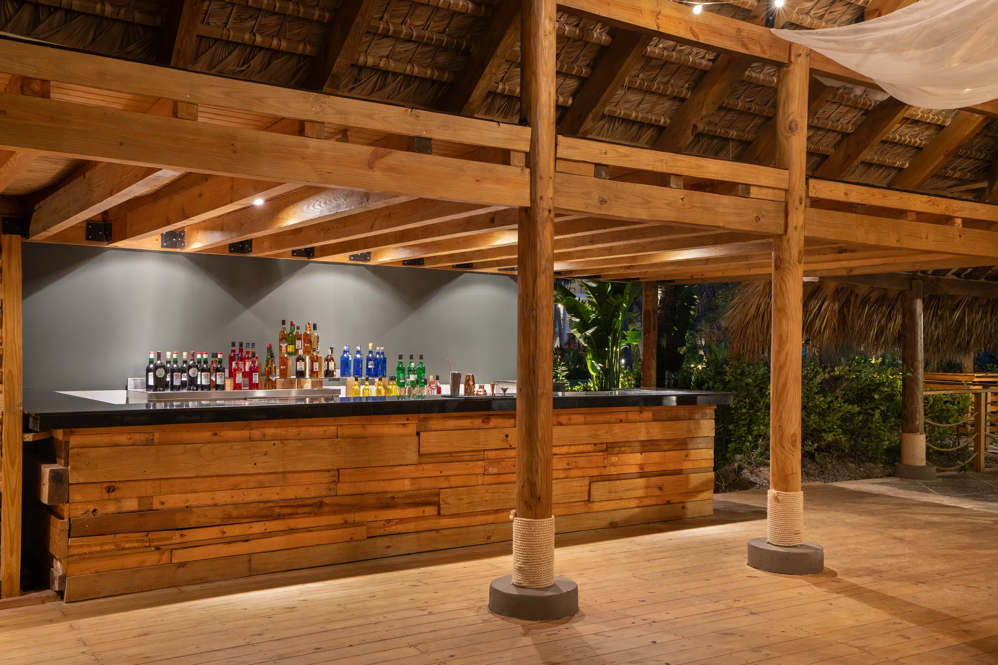 Blue Dorado private event bar at Dreams Flora Resort & Spa featuring a rustic wooden bar, tropical surroundings, and open-air palapa design.