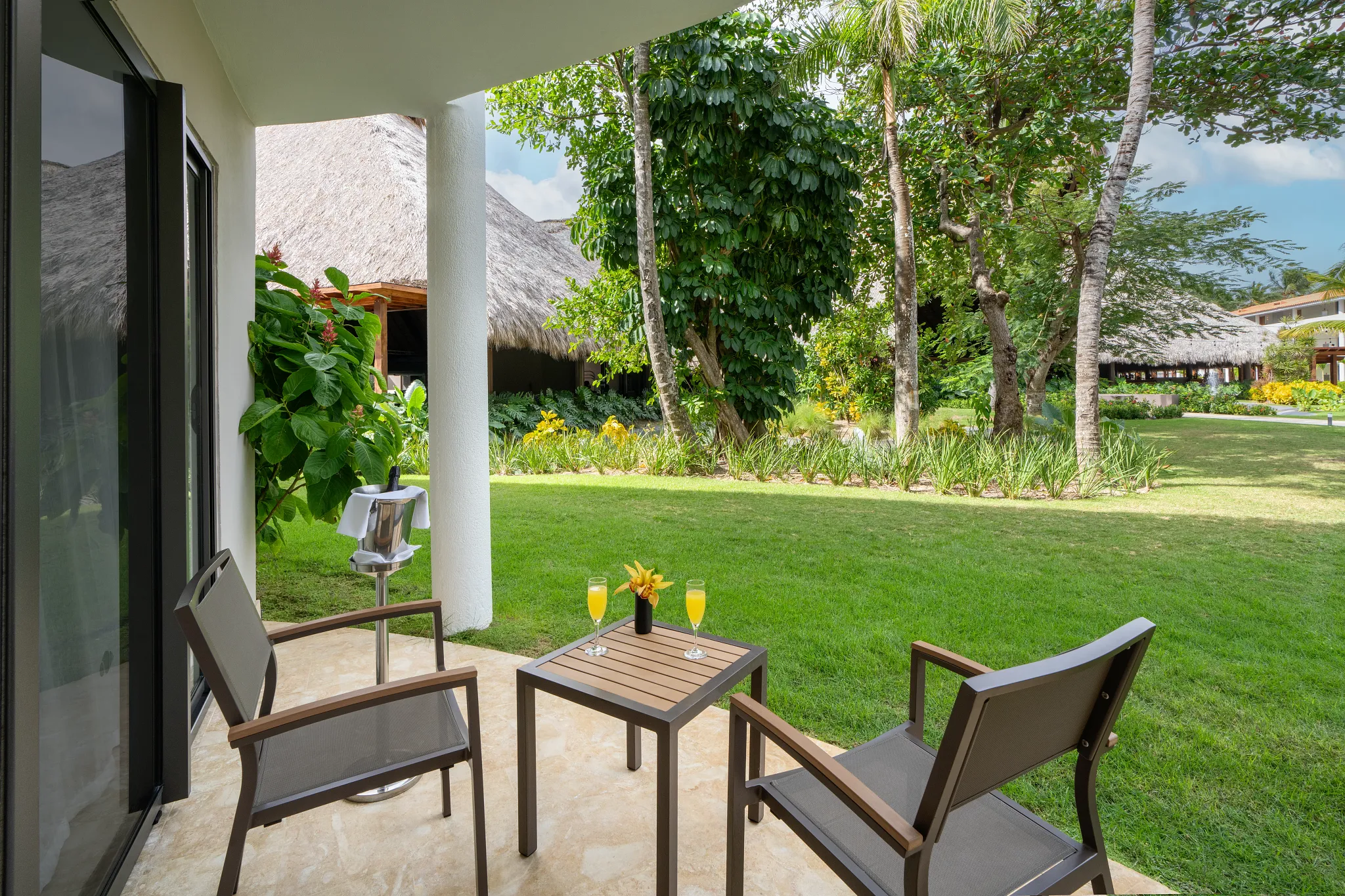 Deluxe Room terrace with garden view and seating area at Dreams Flora Resort & Spa Punta Cana.