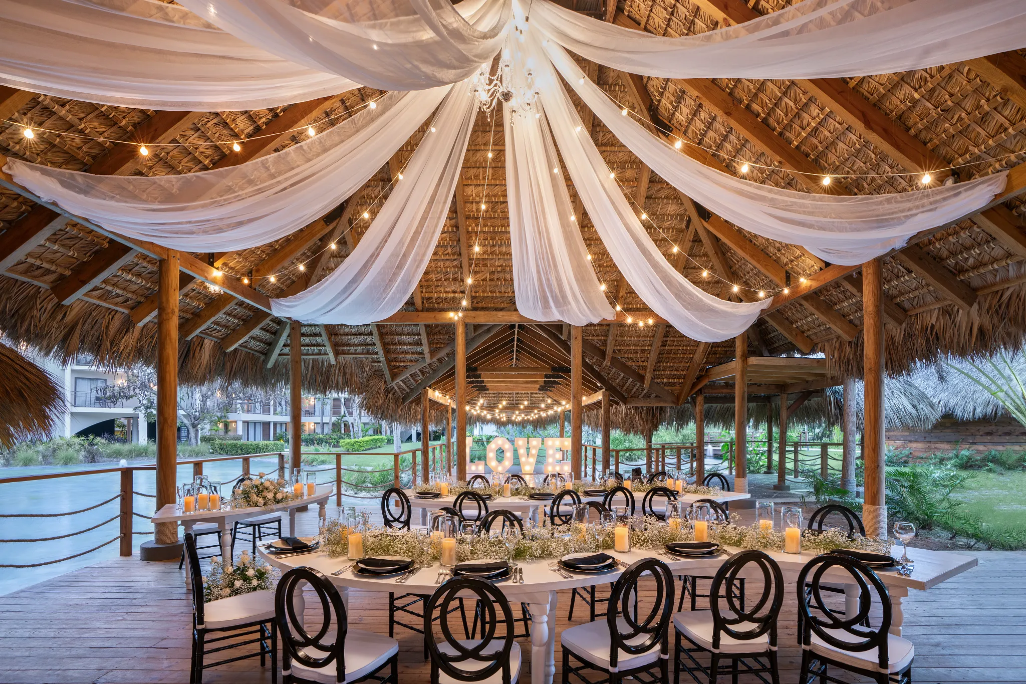 Covered palapa reception venue with draped fabric and string lights at Dreams Flora Resort & Spa