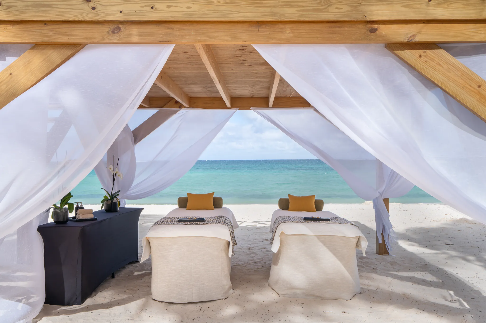 Beachfront spa cabana with massage beds overlooking the ocean at Dreams Flora Resort & Spa Punta Cana.