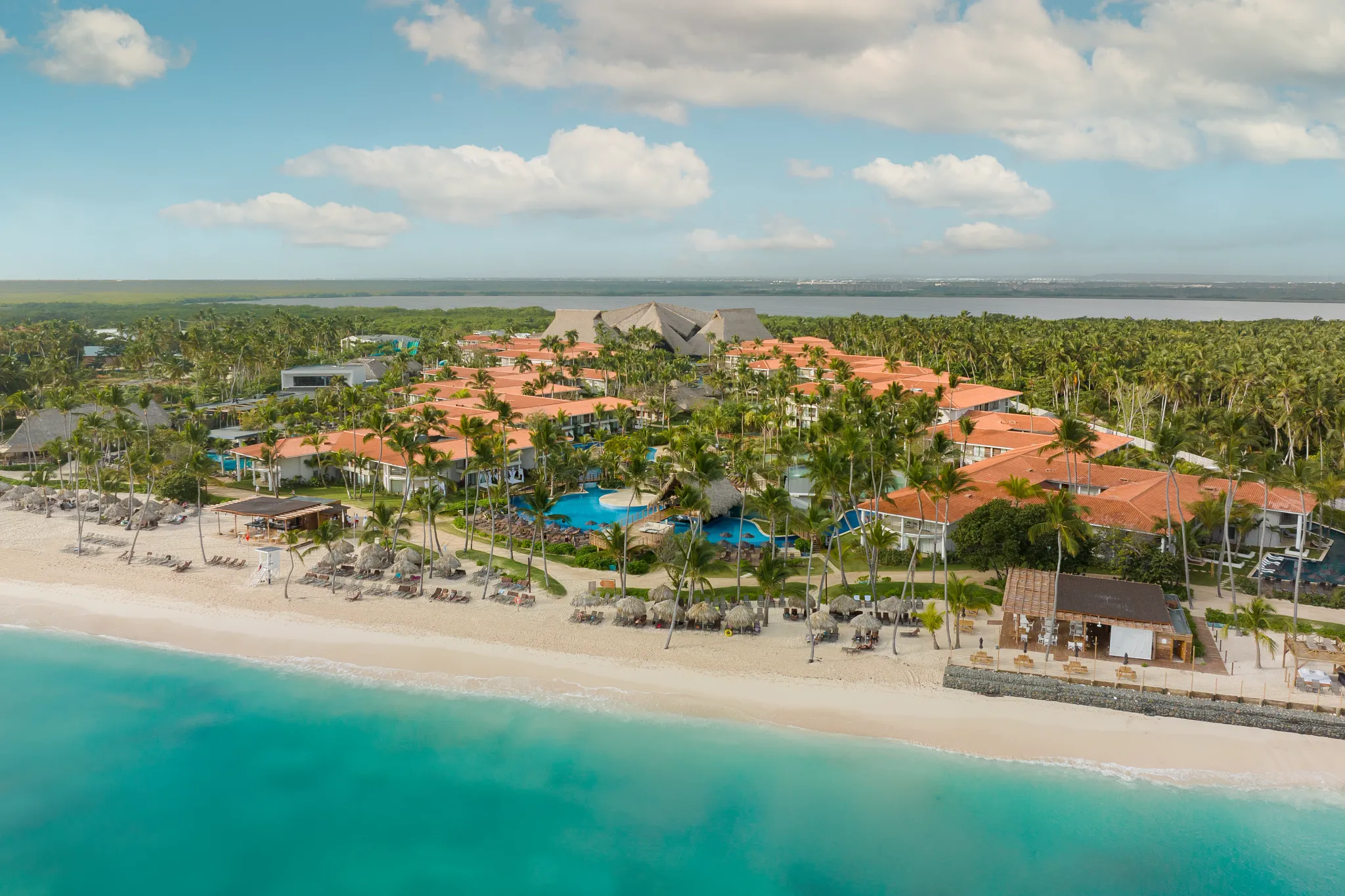 Full aerial view of Dreams Flora Resort & Spa surrounded by lush tropical landscape and coastline in Punta Cana.