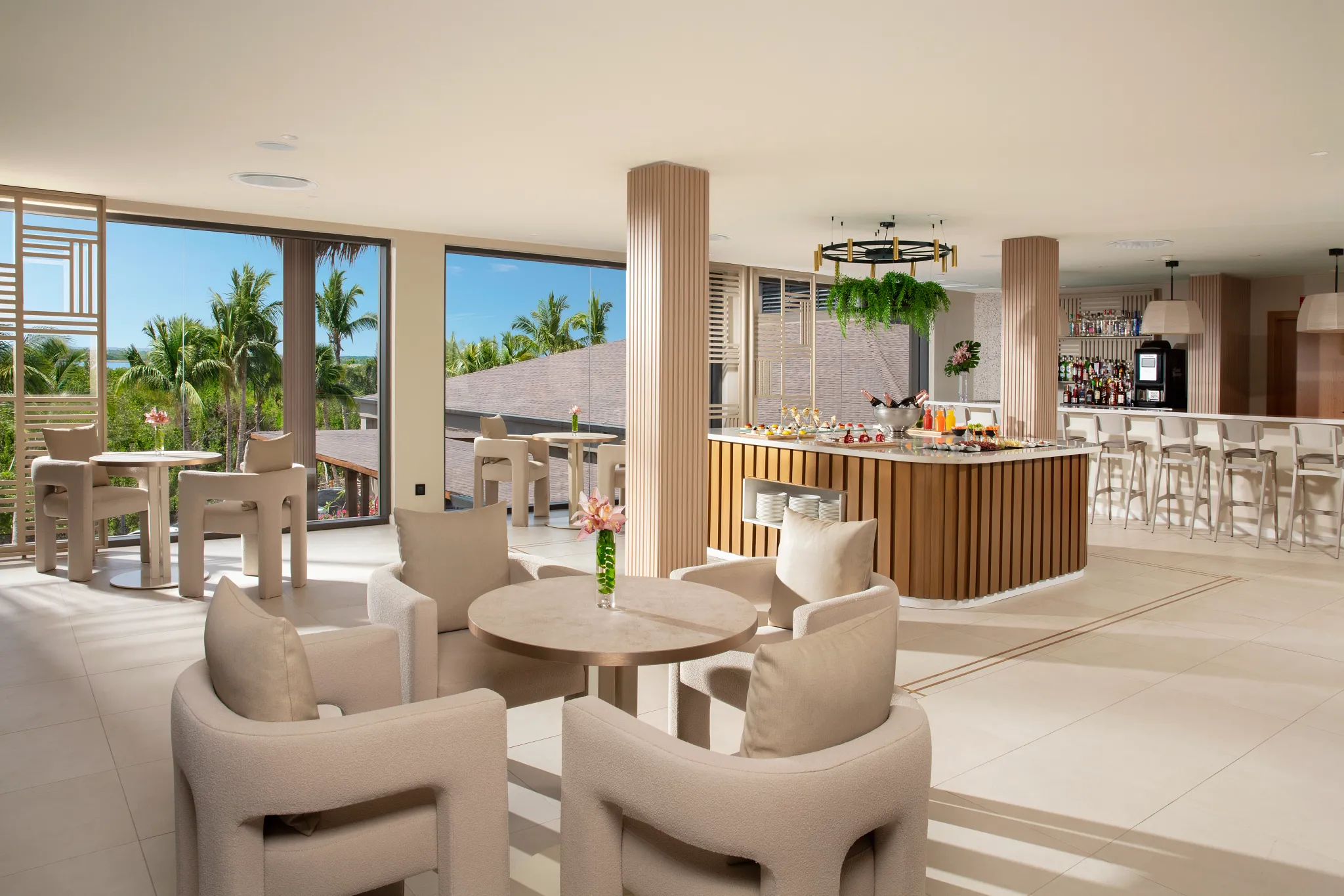 Bright lounge with bar, seating, and palm views at Dreams Flora Resort & Spa Punta Cana.