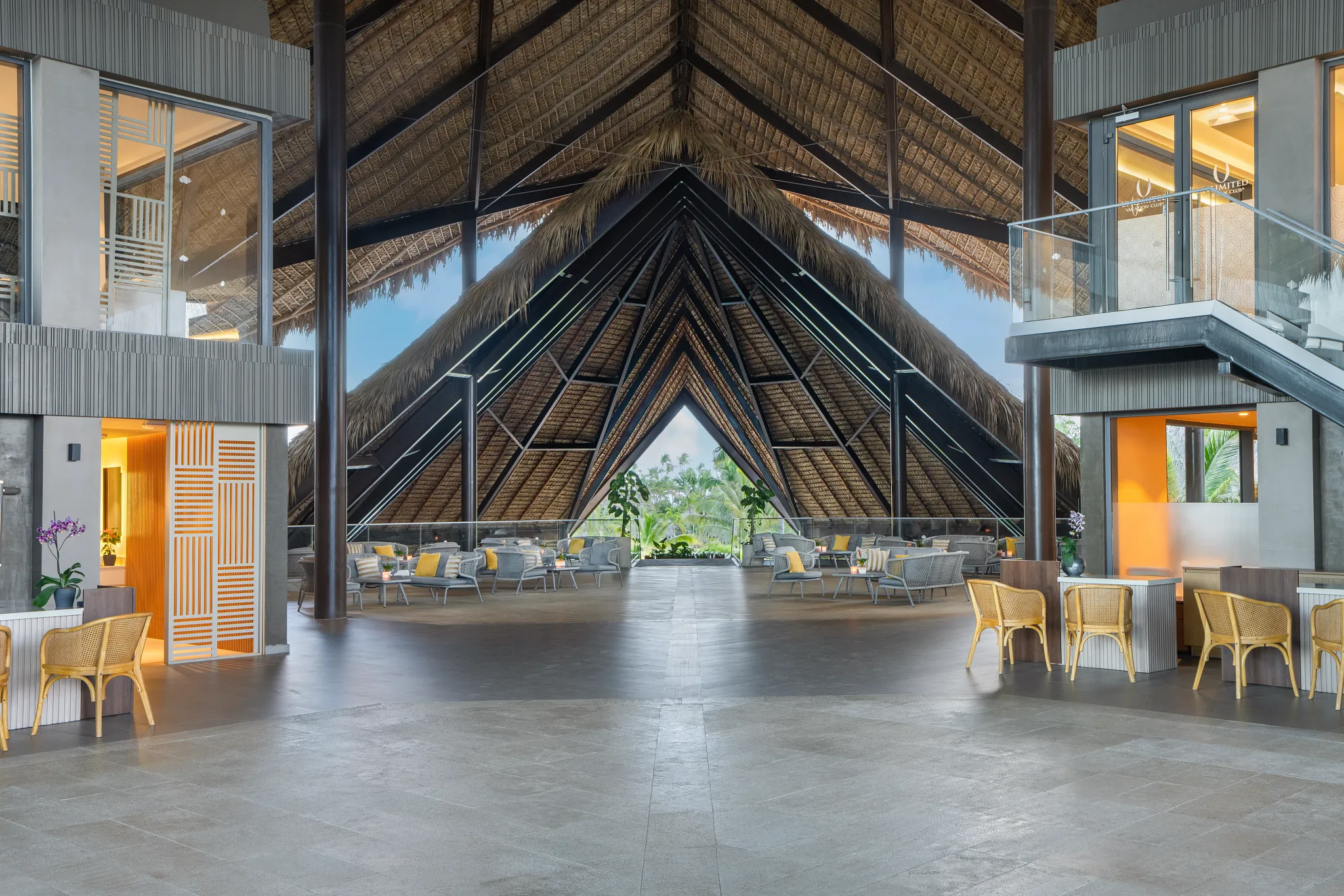 Open-air lobby with high thatched roof and seating areas at Dreams Flora Resort & Spa Punta Cana.