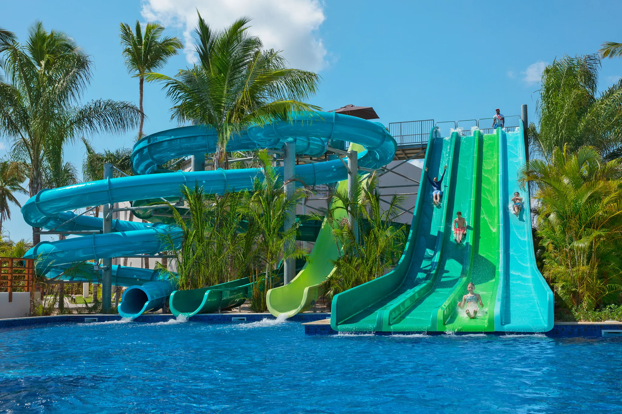 Water park with colorful slides and palm trees at Dreams Flora Resort & Spa Punta Cana.