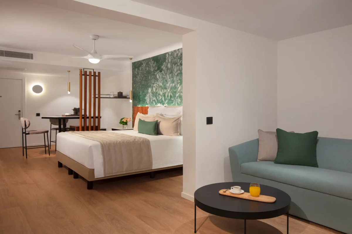 Preferred Club Junior Suite Partial Ocean View king bedroom with seating area at Dreams Flora Resort & Spa.